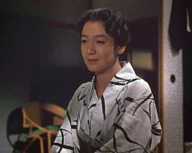 Photo of a woman in a kimono in a modern (20th Century) home, gazing wistfully