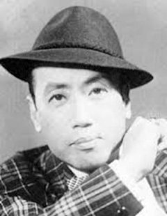 Portrait photo of a middle-aged Japanese man wearing a hat and plaid jacket