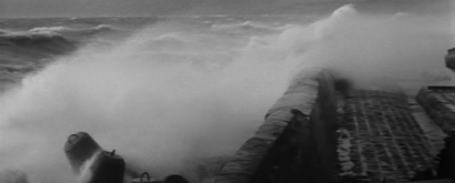 An image of a stormy sea, with waves breaking against the rock on the shor