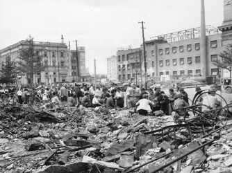 Image of Tokyo after the war with the streets full of rubble and with a crowd of people gathering in the street