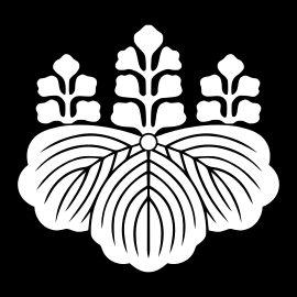 An image of the symbol of the government of Japan: three Paulownia leaves, facing downward, topped by three sets of blossoms in a 5-7-5 pattern