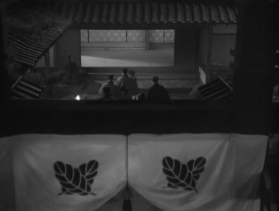 The courtyard of an inn, in which Sankichi and the crowd are visible in the far distance, and the clan's banner in the foreground 