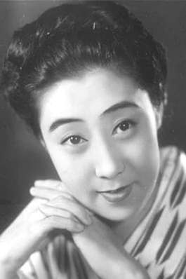 Posed portrait of a Japanese woman in her thirties, smiling at the camera and with her hands folded under her chin